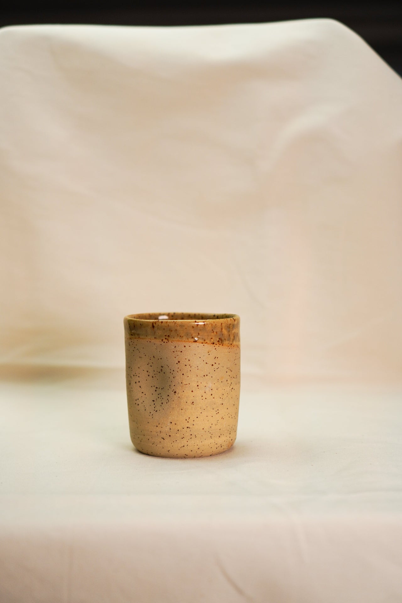 Beżowa ceramiczna czarka z wgnieceniem na dłonie do wygodnego trzymania.