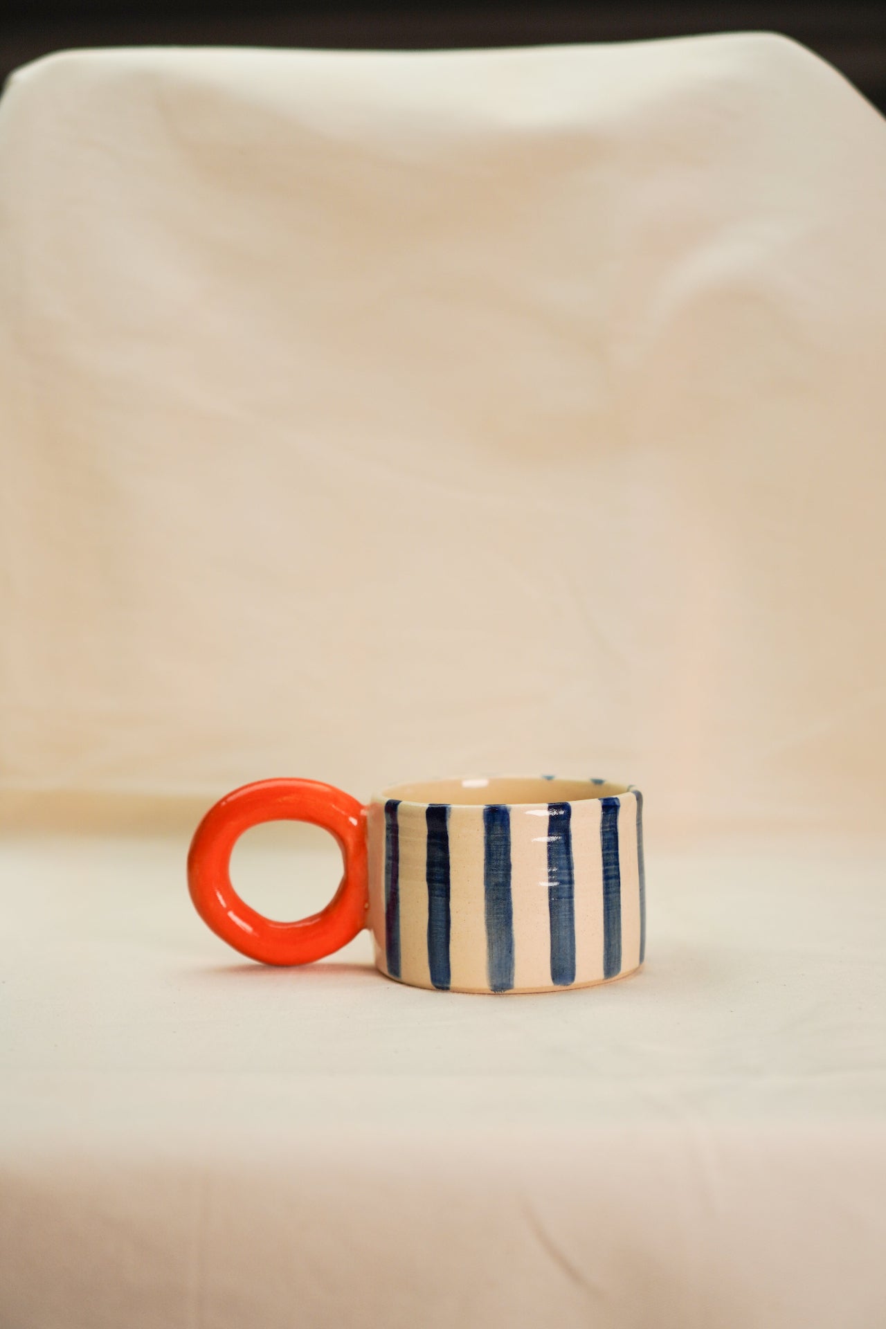 Kubek w paski kobaltowe z okrągłym uchem pomarańczowym