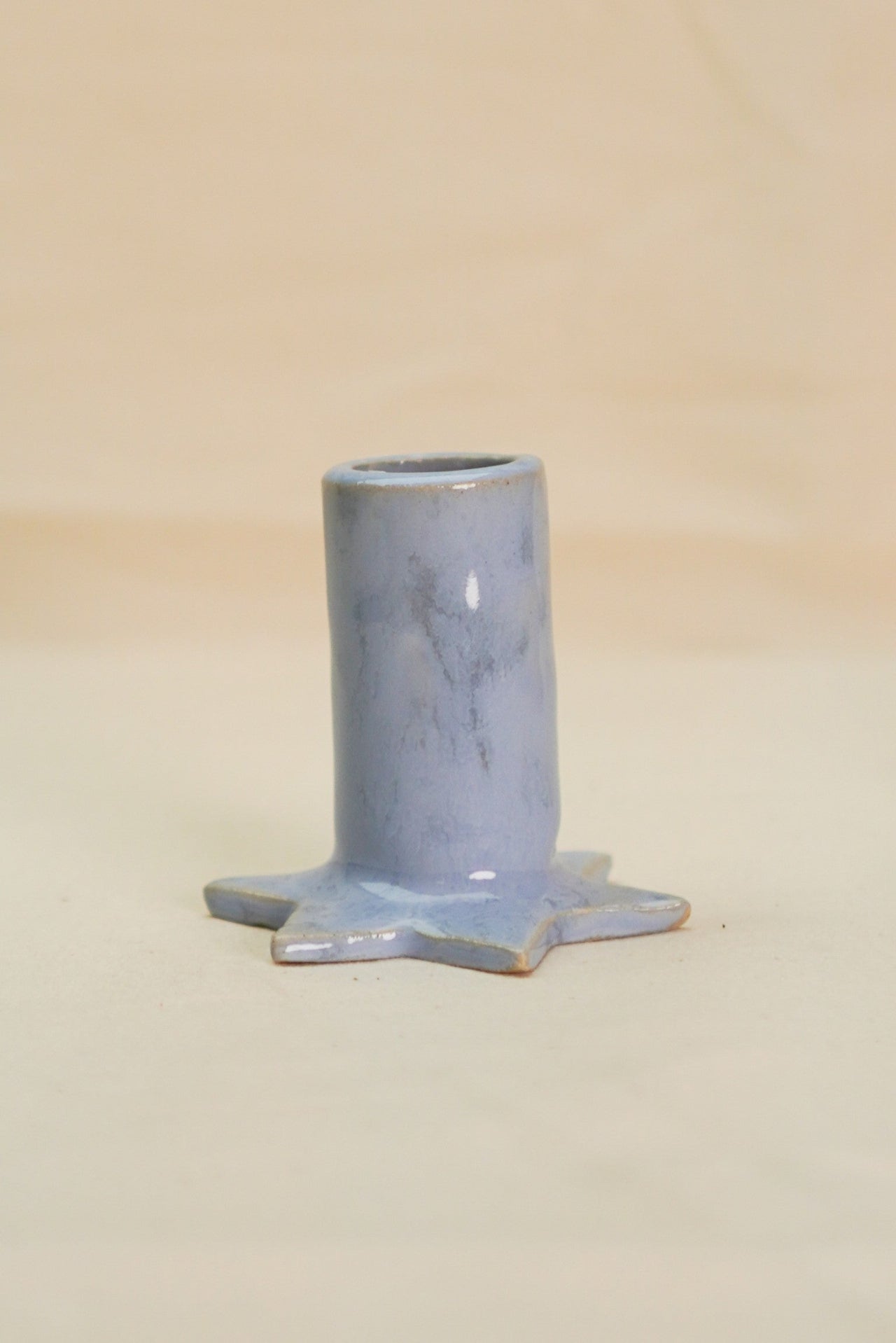 Niebieski świecznik ze spodem w kształcie gwiazdy.