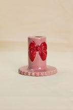 Różowy świecznik z czerwoną kokardą