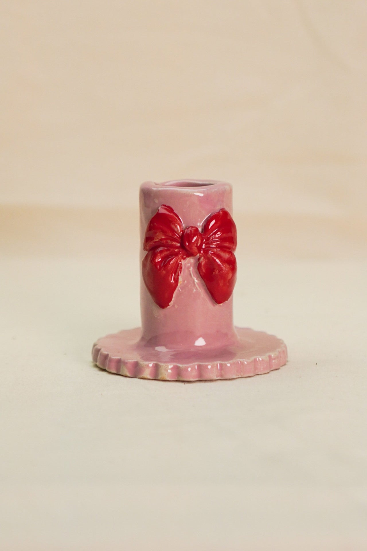 Różowy świecznik z czerwoną kokardą