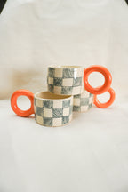 Filiżanki w kratkę z pomarańczowym uchem